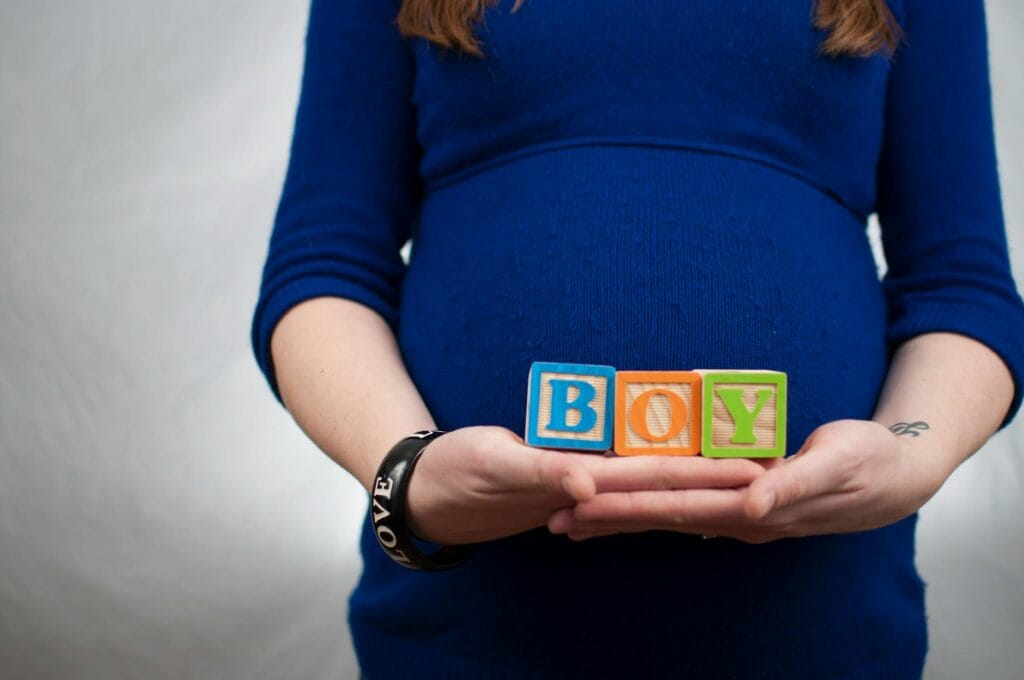 lady wearing lbue long sleeve dress and holding boy piece box
