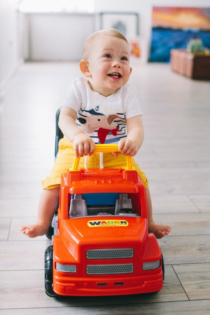 a boy riding on a plastic toy car