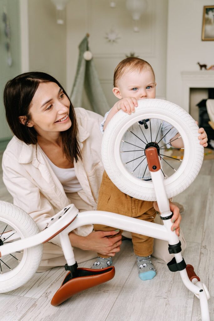 woman in white long sleeve shirt holding baby near a bicycle